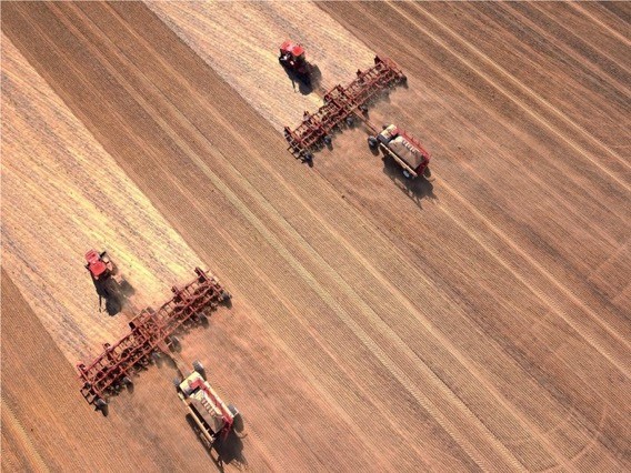 Aerial view of two seeding machines working over paddock